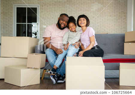 Mixed Race families are sitting on the sofa for rest after moving to a new house on the first day after buying real estate. Concept of starting a new life for a new family. Mixed Race families are sitting on the sofa for rest after moving to a new house on the first day after buying real estate. Concept of starting a new life for a new family. 106725664