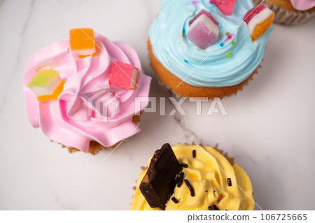 Delicious homemade cupcakes with Colorful cream and topping with candy and Chocolate Cookies. Homemade autumn holiday dessert 106725665