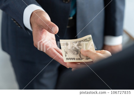 Hands of a man and woman handing over money Hands of a man and woman handing over money 106727835