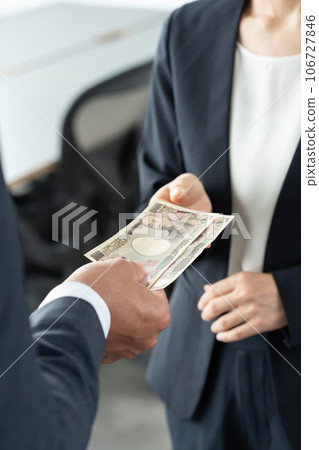Hands of a man and woman handing over money Hands of a man and woman handing over money 106727846
