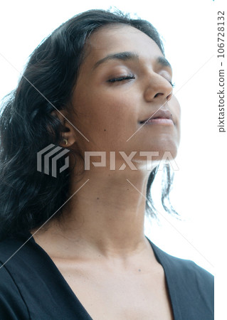 A portrait of a woman with closed eyes and a smile on a white background 106728132