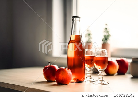 Seasonal drink cider from ripe apples, apple wine in small glasses and bottles on kitchen table 106728142