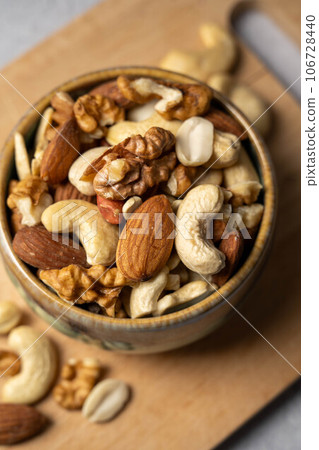 Mix of nuts cashews, almonds, hazelnuts in a small bowl. 106728440