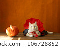 Halloween cute cat in a vampire costume and pumpkin a orange background. 106728852