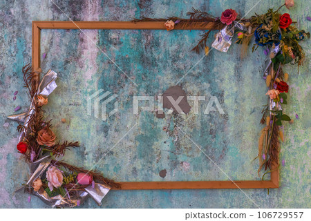 Empty wooden frame with flowers and dry leaves on blue Empty wooden frame with flowers and dry leaves on blue 106729557