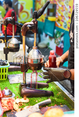 Process of making pomegranate juice in Jalan Alor street food in Malaysia 106729559