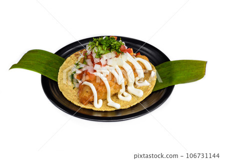 Taco condesa with fried fish on black plate isolated on white background site view 106731144