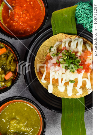 Taco condesa with fried fish on black plate with mexican sauces Taco condesa with fried fish on black plate with mexican sauces 106731297