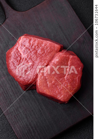 Raw fillet steak mignon beef with salt, spices and herbs Raw fillet steak mignon beef with salt, spices and herbs 106731644
