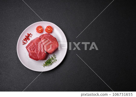 Raw fillet steak mignon beef with salt, spices and herbs Raw fillet steak mignon beef with salt, spices and herbs 106731655