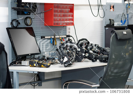 workplace of the assembler of robots, mechanical hands lie on the desktop 106731808