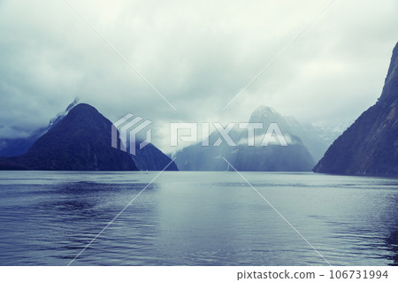 Photograph of mountains in clouds and mist in Milford Sound on the South Island of New Zealand 106731994