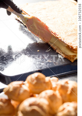 Making a Napoleon cake with poppy seeds and cherries 106732038