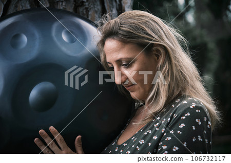Portrait of a woman with a handpan her hands 106732117