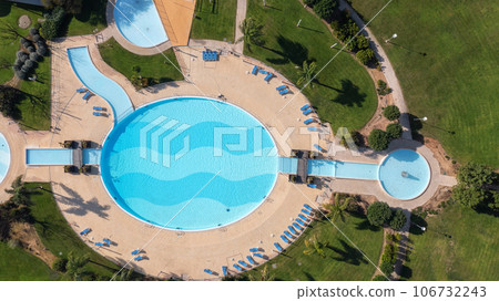 The original round swimming pool with sun loungers in the garden, aerial view. 106732243