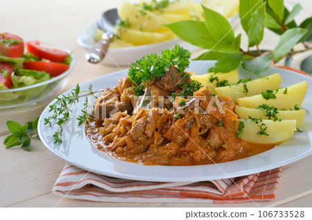 Typical Hungarian goulash (pork and beef) with sauerkraut and boiled potatoes Typical Hungarian goulash (pork and beef) with sauerkraut and boiled potatoes 106733528