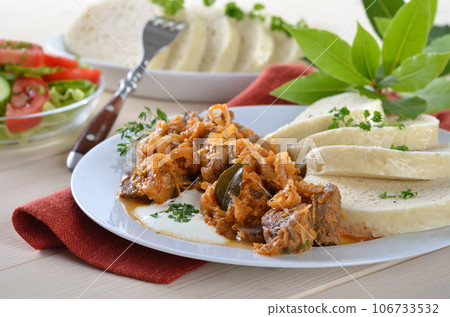 Typical Hungarian goulash (pork and beef) with sauerkraut and Bohemian dumplings Typical Hungarian goulash (pork and beef) with sauerkraut and Bohemian dumplings 106733532