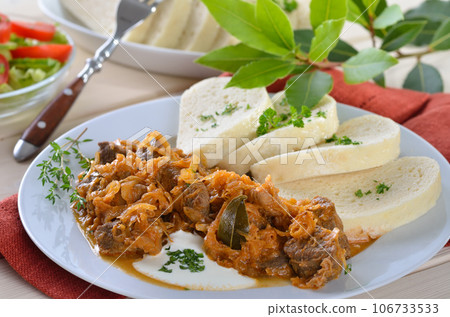 Typical Hungarian goulash (pork and beef) with sauerkraut and Bohemian dumplings Typical Hungarian goulash (pork and beef) with sauerkraut and Bohemian dumplings 106733533