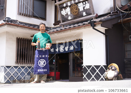 一家味噌和醬油釀酒廠矗立在一家老式商店前 106733661