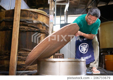 A craftsman working at a traditional miso and soy sauce brewery A craftsman working at a traditional miso and soy sauce brewery 106733679