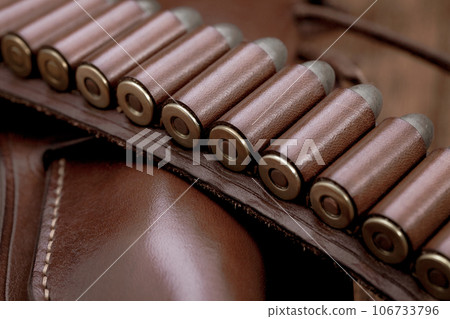 Leather gun belt with ammnunitions and revolver in holster 106733796