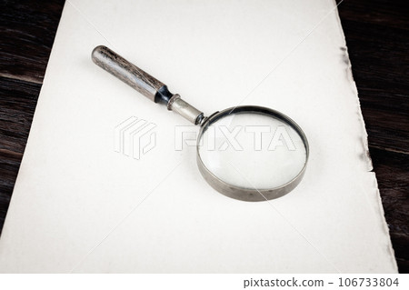 Antique vintage magnifying glass with old paper Antique vintage magnifying glass with old paper 106733804