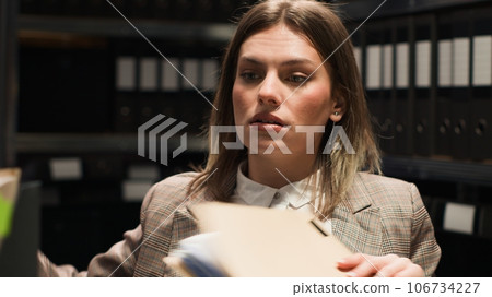 African american inspector asking female investigator for forensic report and suspect information. Multiethnic police partners conducting investigations to solve organized crime. Close-up handheld. 106734227