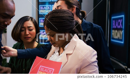 Mad diverse people at store entrance going crazy for black friday deals and promotions. African american security agent managing crowd control during seasonal sales at boutique. 106734245