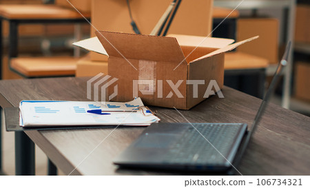 Office space in storage room filled with shipping boxes, warehouse used for products distribution and quality control management. Small business place with merchandise and goods. Office space in storage room filled with shipping boxes, warehouse used for products distribution and quality control management. Small business place with merchandise and goods. 106734321