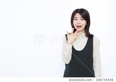 A woman in her thirties who is surprised in front of a white background 106734348