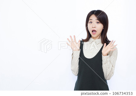 A woman in her thirties who is surprised in front of a white background 106734353