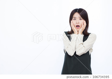 一個三十多歲的女人，在白色背景前感到驚訝 106734395