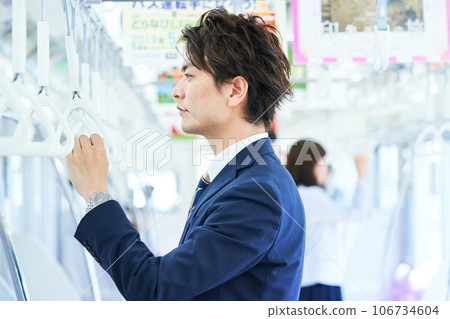 A man in a suit riding a train Photo cooperation "Keio Electric Railway Co., Ltd." 106734604