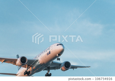 [ANA aircraft Star Alliance in preparation for landing from the sky above Jonanjima Seaside Park at sunset] 106734916