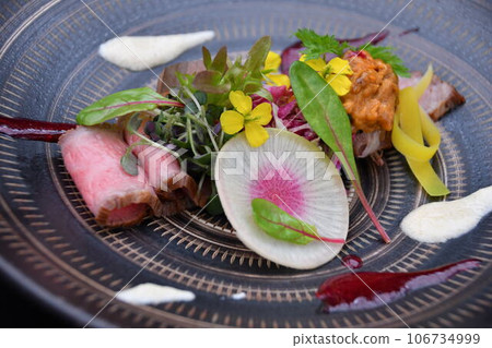 日本黑毛牛肉烤牛肉飾有食用花卉和香草。 日本黑毛牛肉烤牛肉飾有食用花卉和香草。 106734999