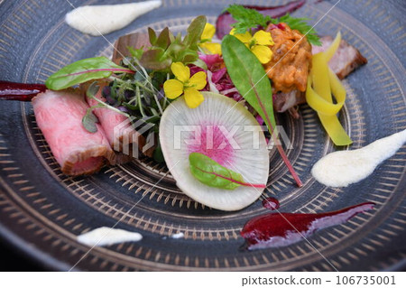 日本黑毛牛肉烤牛肉飾有食用花卉和香草。 日本黑毛牛肉烤牛肉飾有食用花卉和香草。 106735001