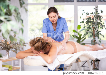 Portrait of woman relaxing on massage table at spa center Portrait of woman relaxing on massage table at spa center 106736115