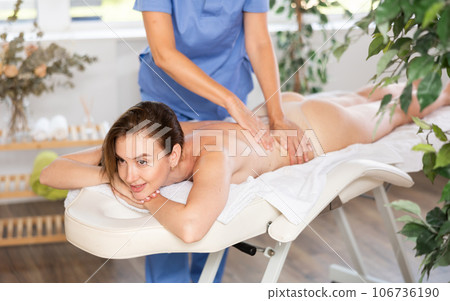 Young woman enjoying massage from professional female masseur 106736190