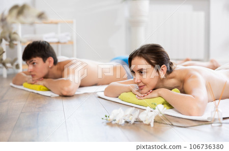 Relaxed young woman lying on the floor during aromatherapy procedure 106736380