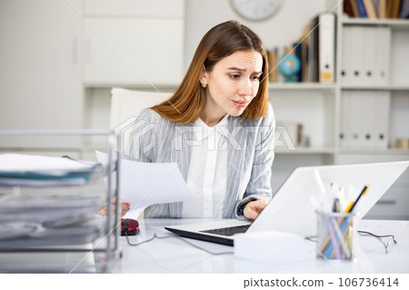 Tired businesswoman working with documents in office 106736414