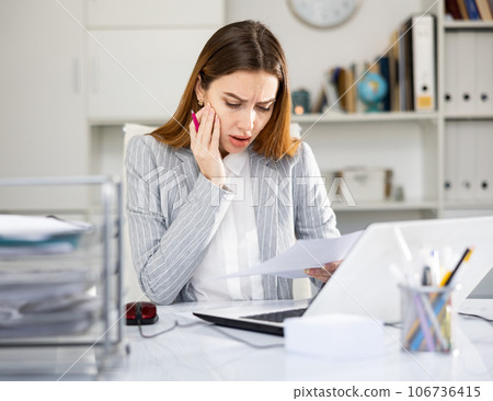 Portrait of young woman office worker sitting at table 106736415