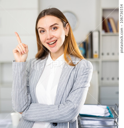 Business woman standing in office and pointing 106736554