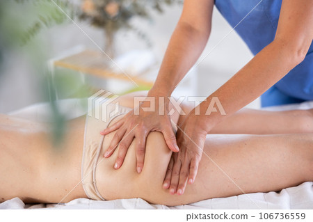 Closeup of hands of masseur who makes an anti-cellulite massage of the thighs and buttocks of woman Closeup of hands of masseur who makes an anti-cellulite massage of the thighs and buttocks of woman 106736559