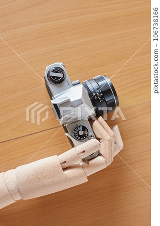 A mannequin holding a film camera in one hand 106738166
