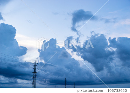 Black clouds on a summer evening rising in the sky behind the power transmission tower c-1 106738630