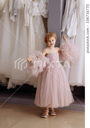Girl in a lush pink evening dress in a clothing boutique Girl in a lush pink evening dress in a clothing boutique 106738770