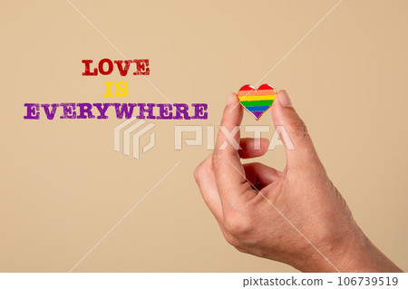 Love is everywhere. Miniature heart in a woman's hand on a light background Love is everywhere. Miniature heart in a woman's hand on a light background 106739519