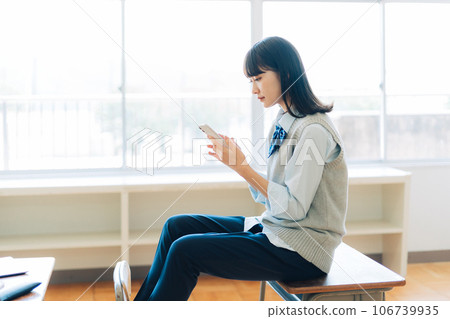 拿著智能手機的褲子風格的高中女孩 106739935