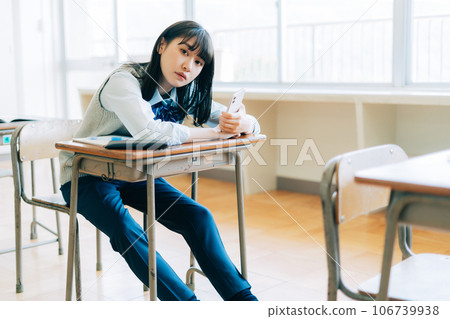 High school girl in pants style holding a smartphone High school girl in pants style holding a smartphone 106739938