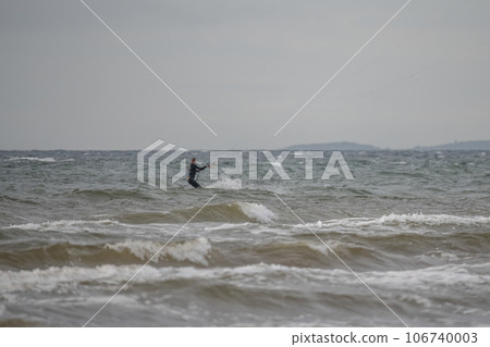 Melbystrand Sweden A kitesurfer practise his surfing skills close to beach with sand dunes 106740003
